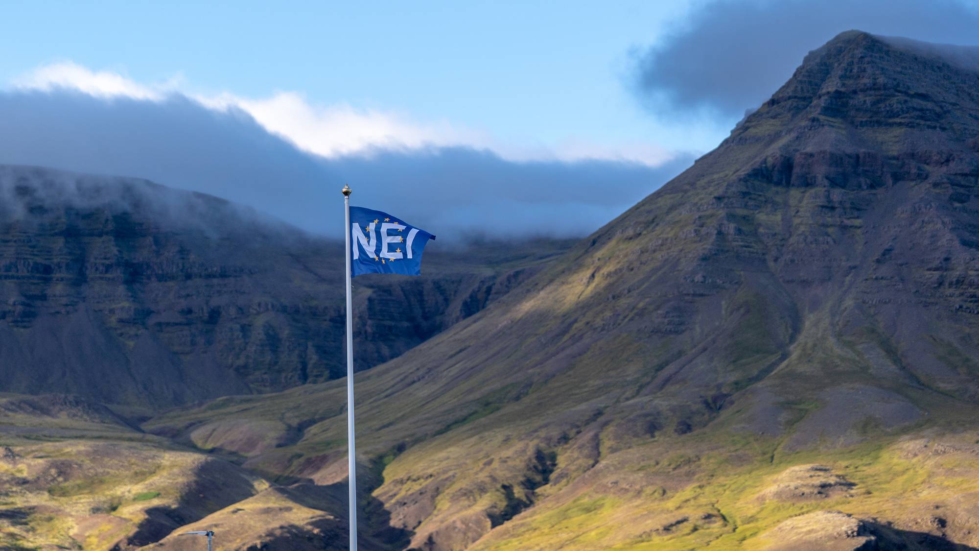 Blått flagg med hvit skift hvor det står nei, i flaggstang på Island
