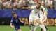 RICHARD PELHAM / GETTY IMAGES NORTH AMERICA,NTB Fotballspiller Luka Modrić, iført Kroatias blå drakt, går ned på bakken under en kamp. Harry Kane, i Englands hvite drakt, løper forbi. En annen spiller, iført hvitt med nummer 8, sees i bakgrunnen. Kampen foregår på en fotballbane med et publikum på tribunen. (Bildebeskrivelsen er laget av en KI-tjeneste)