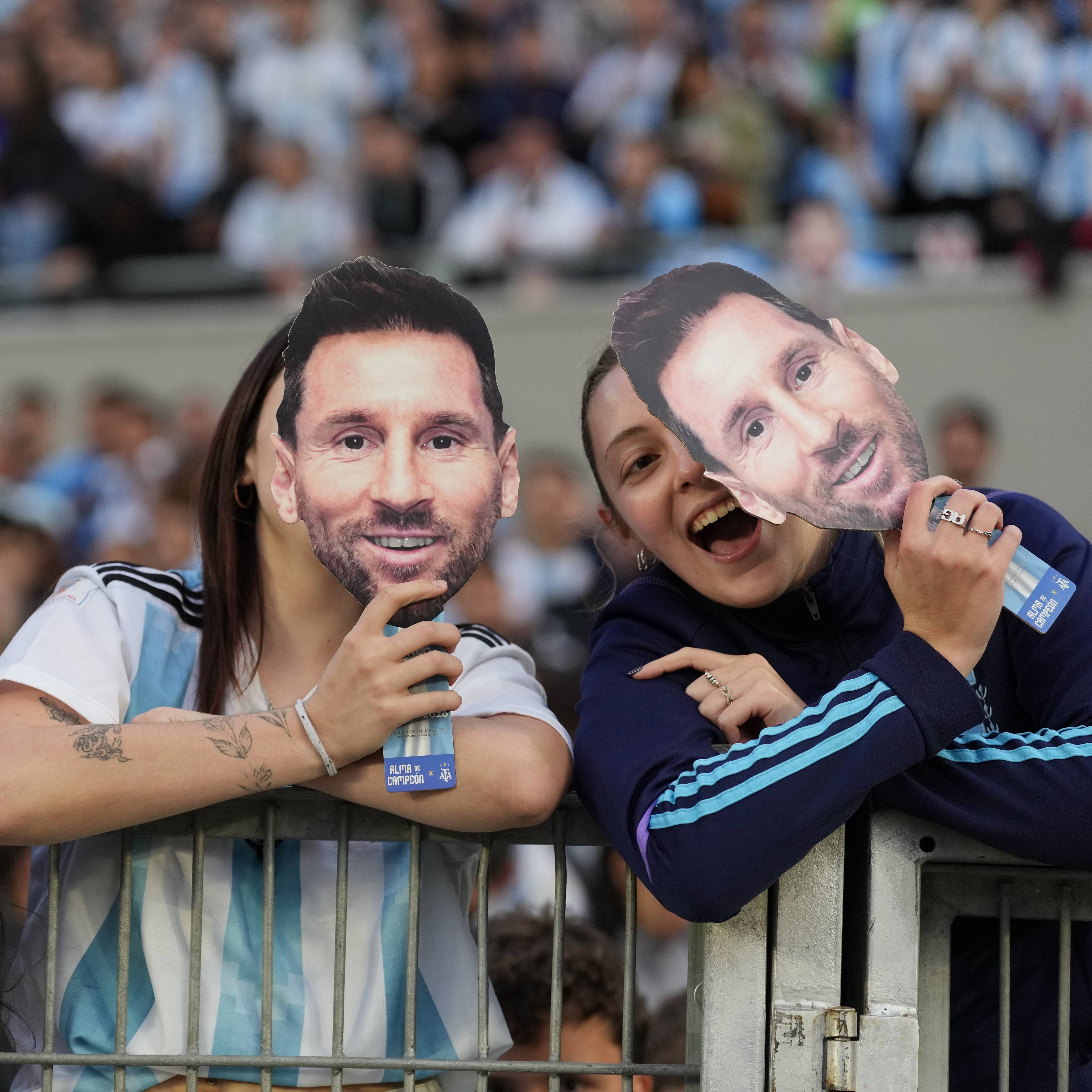 Supportere holder opp masker av Lionel Messi på tribunen under en fotballkamp. (Bildebeskrivelsen er laget av en KI-tjeneste)