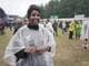 Terje Haugnes / NRK Smilende kvinne i regnponcho på festivalområde med publikum i bakgrunnen. (Bildebeskrivelsen er laget av en KI-tjeneste)