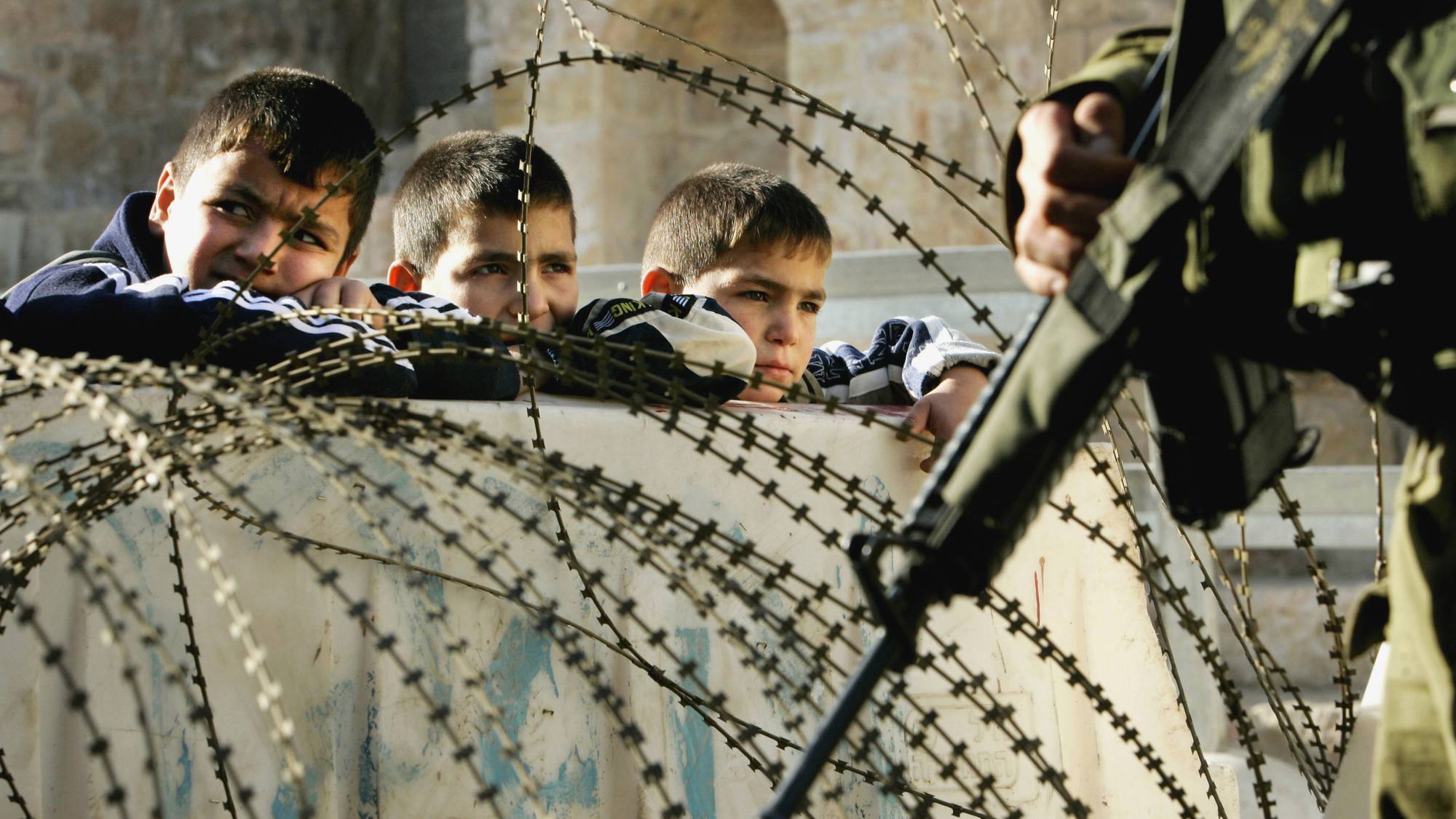 Palestinske skolebarn venter på å få krysse en israelsk kontrollpost i 2005. 