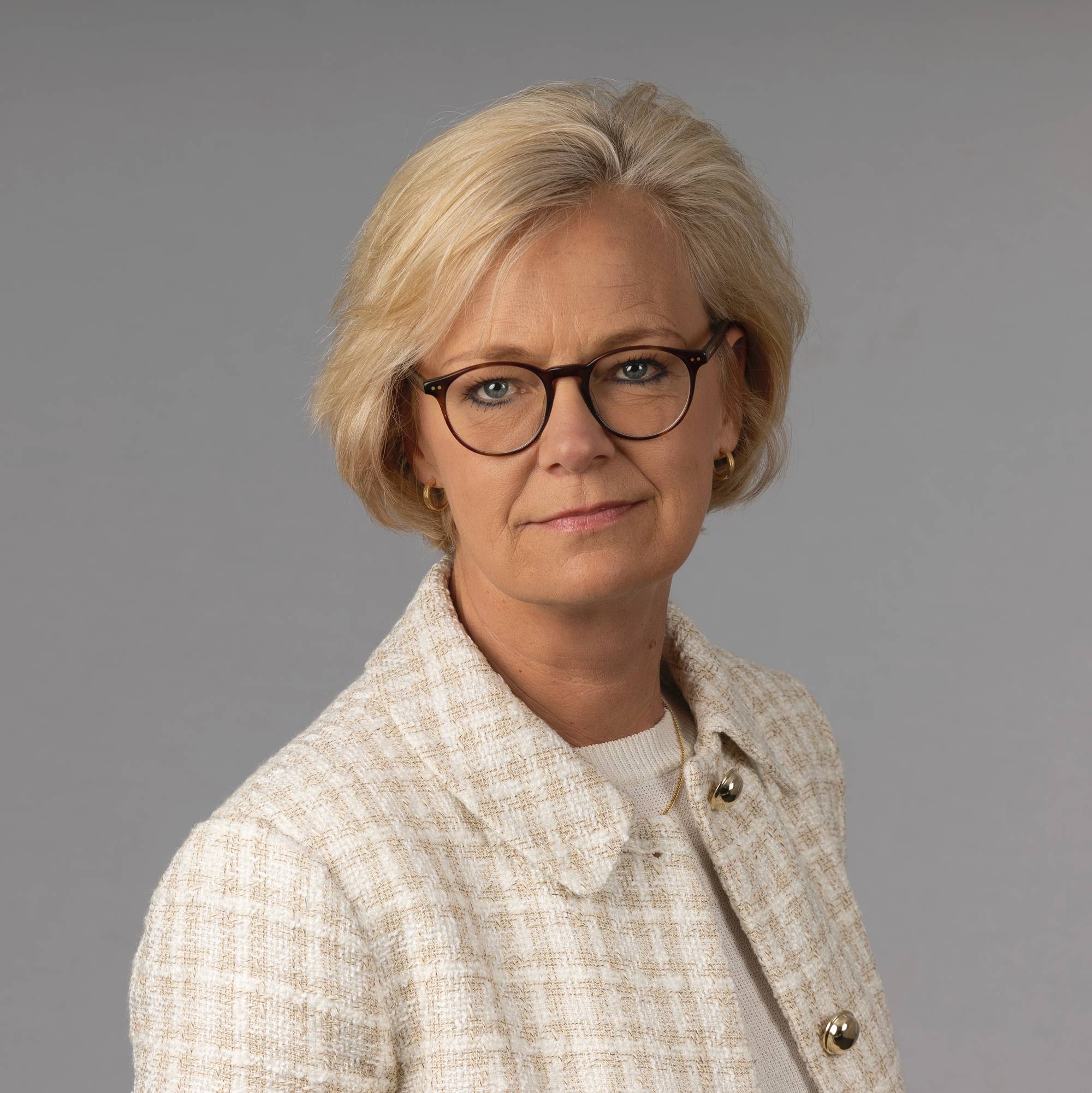 Et portrettbilde av en kvinne med briller og kort hår