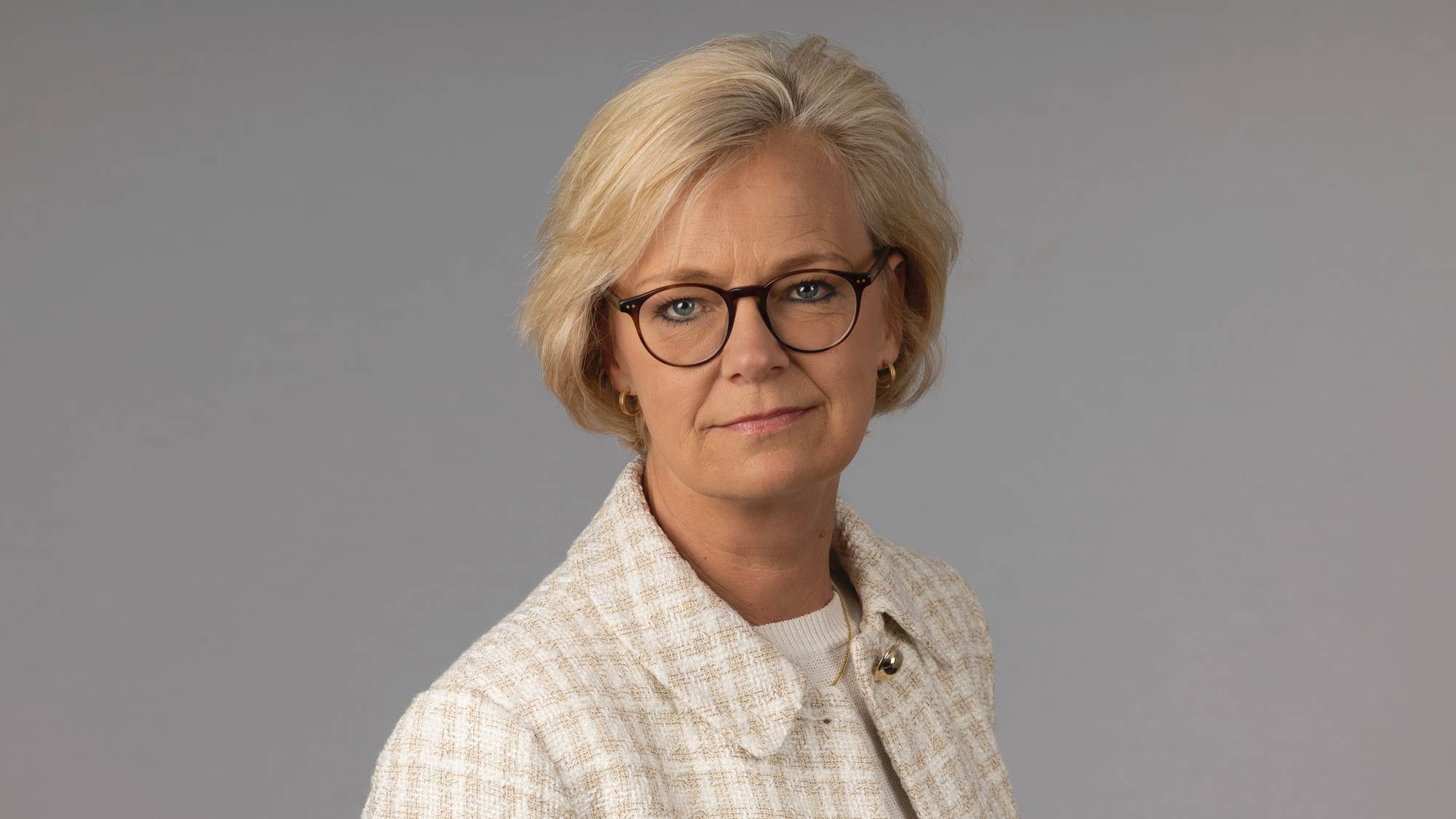 Et portrettbilde av en kvinne med briller og kort hår