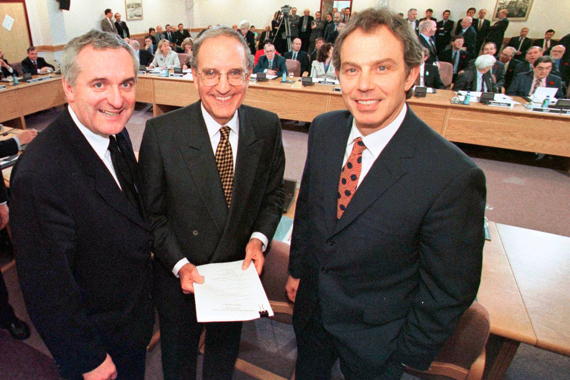 Bertie Ahern, George Mitchell og Tony Blair i en forhandlingssal. (Bildebeskrivelsen er laget av en KI-tjeneste)