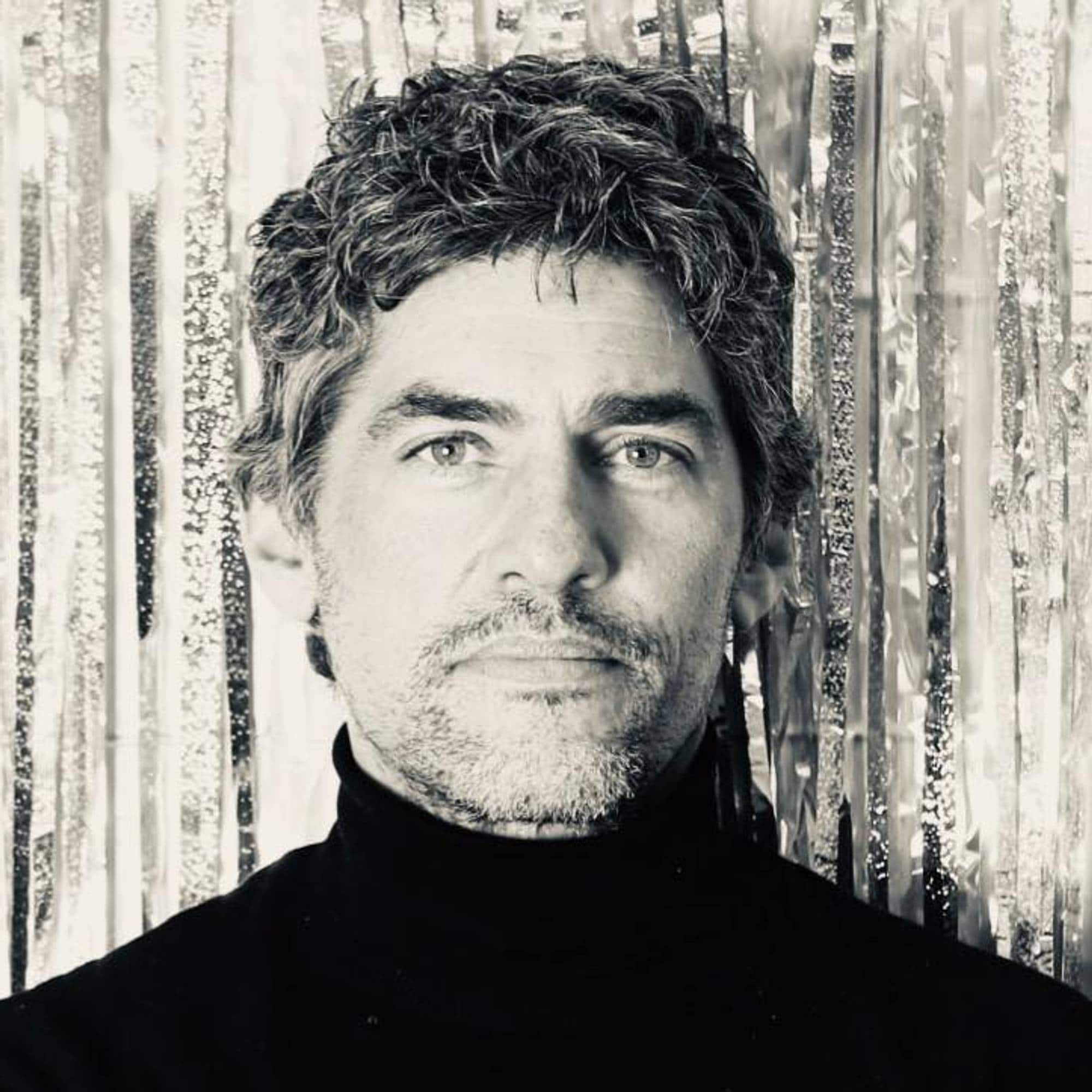 Profilbilete av Fabian Mosenson. Svart-kvitt. Han har på svart pologenser og står foran ein trevegg.