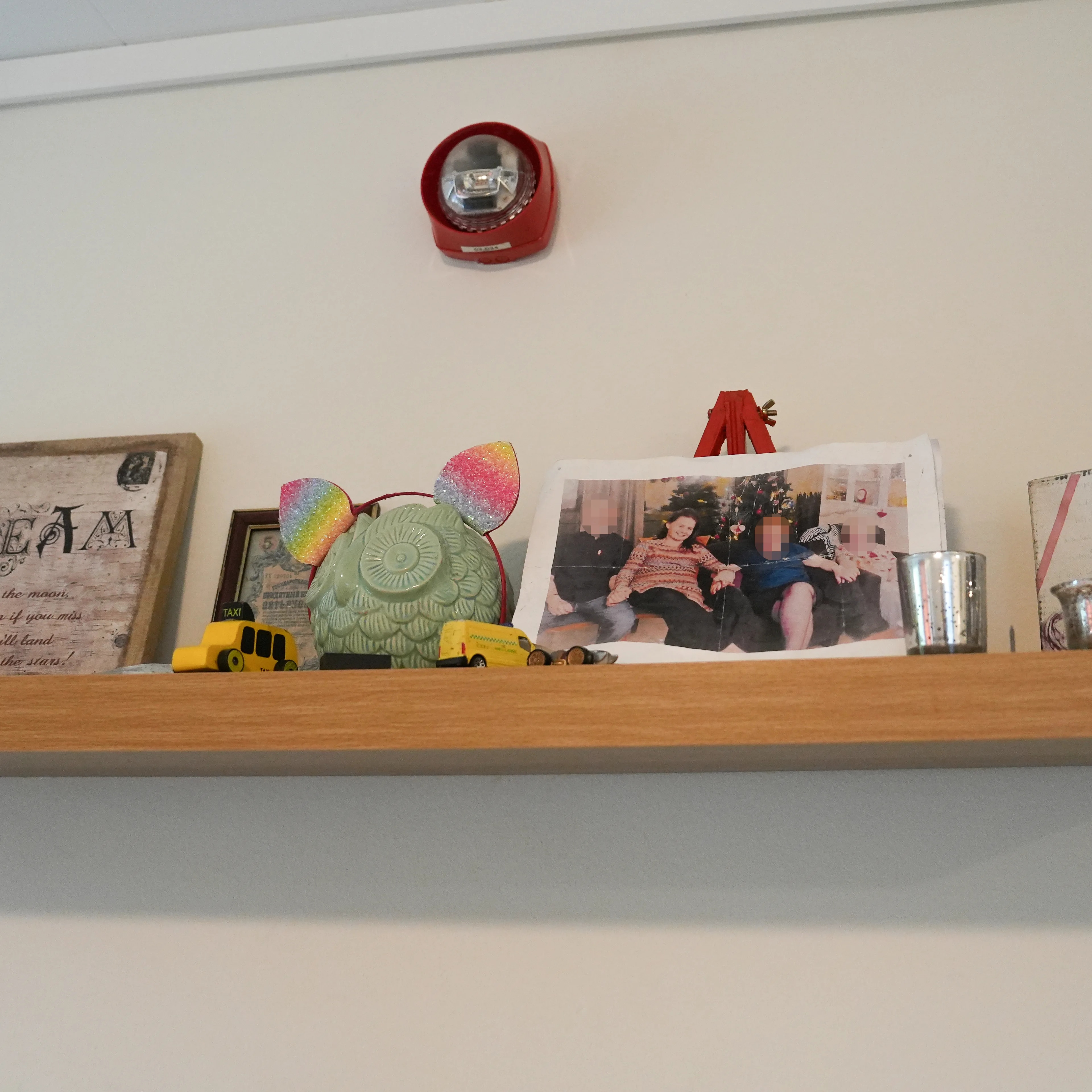 En vegghylle med bilder og pynt