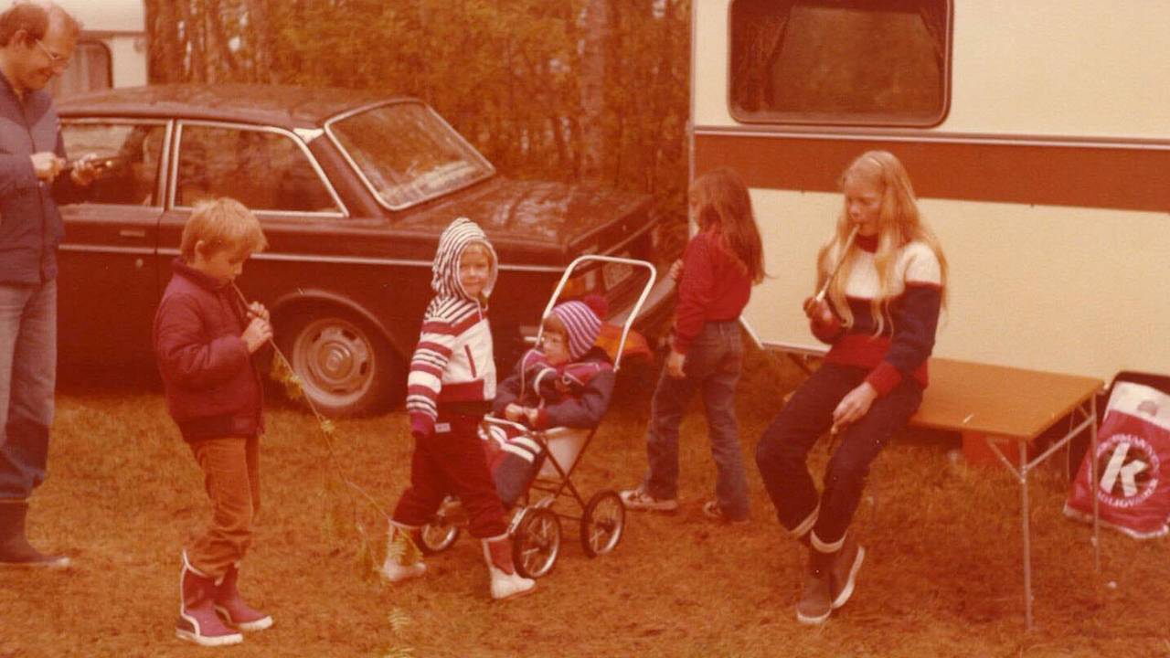 Eva Helen Angvik-Kristiansen sitter i vogn. Søsteren Anne Kathrine Angvik spiller blokkfløyte