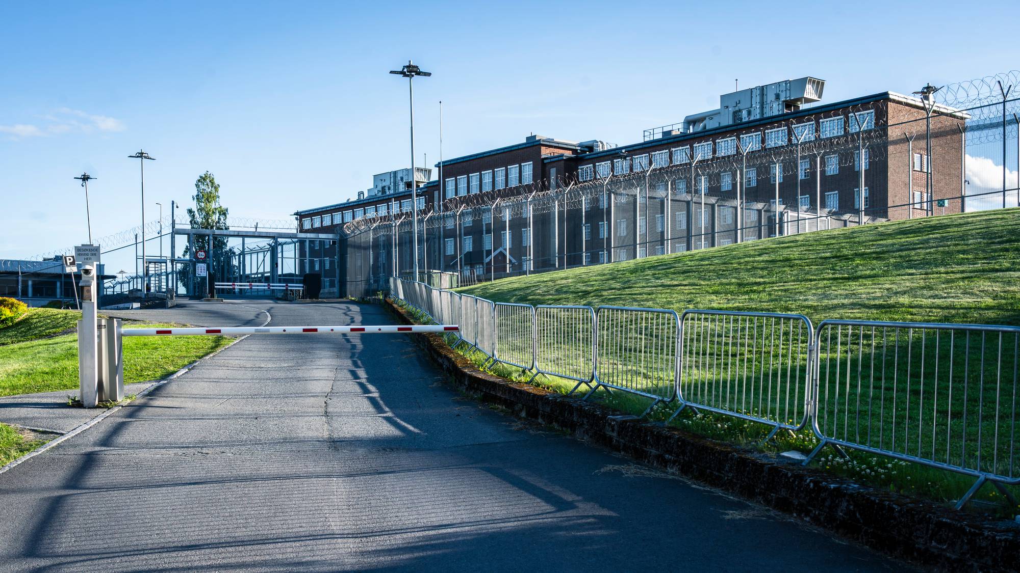 fengselet med høye piggtrådgjerder bader i solnedgangen