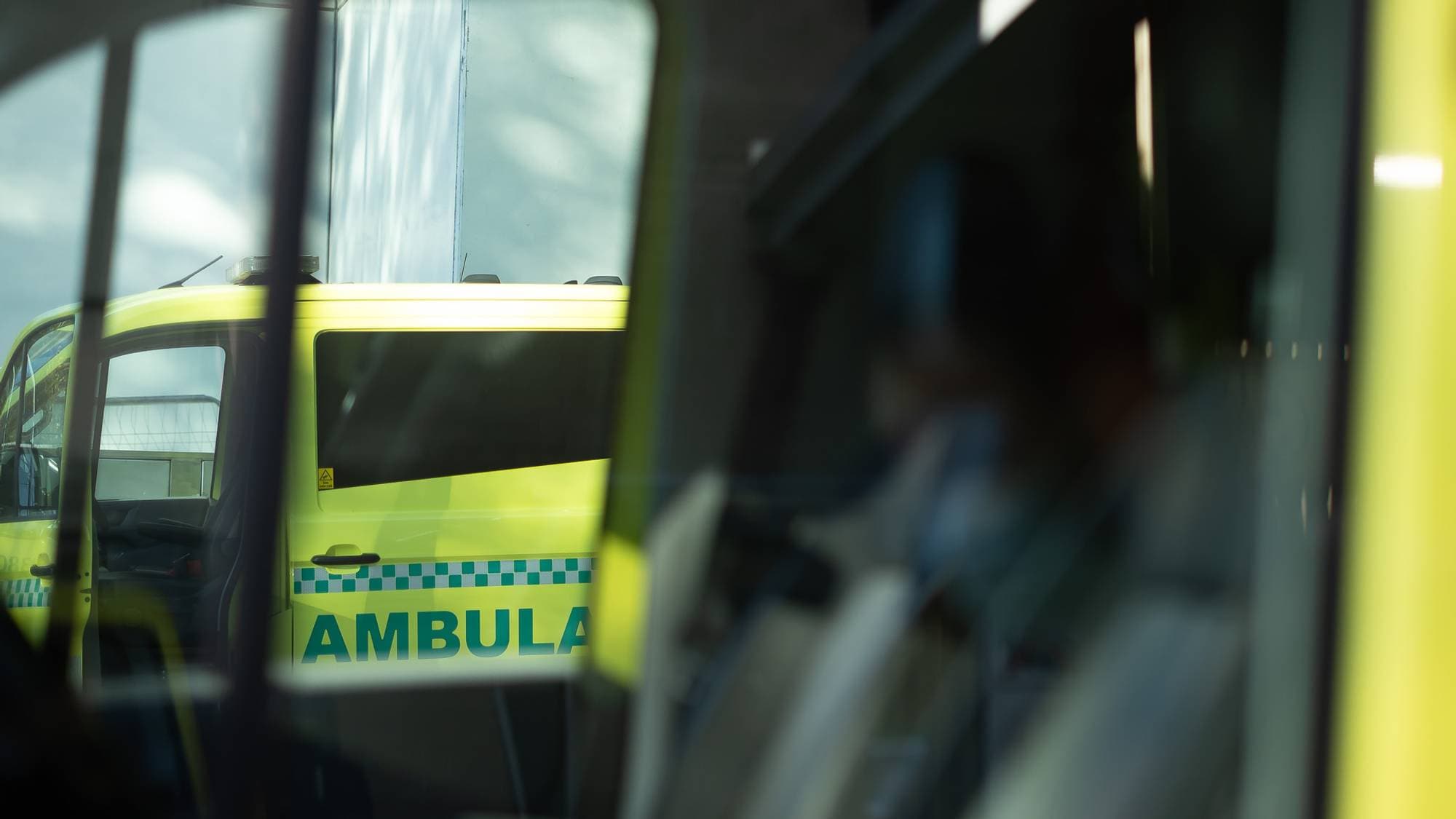 Vi ser inn i førerhuset i en ambulanse. Gjennom vinduene ser vi enda en ambulanse i bakgrunnen.