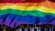 Ap Fans support an oversized rainbow flag before the Vancouver Whitecaps play the Seattle Sounders in an MLS soccer game in Vancouver.
