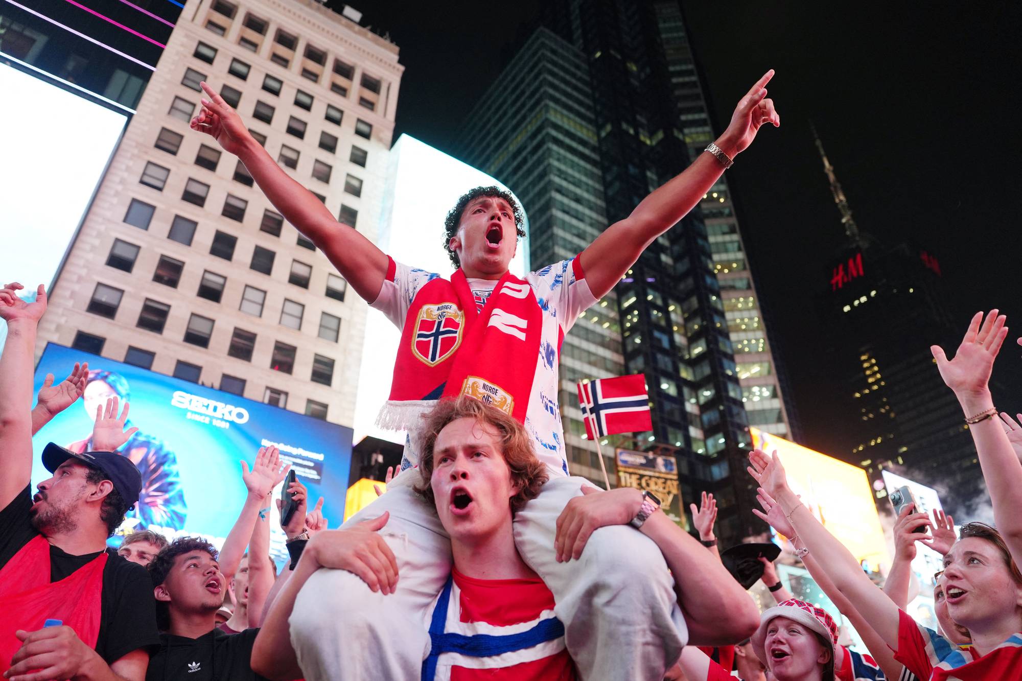 Personer i norske landslagsdrakter jubler på Times Square i New York.