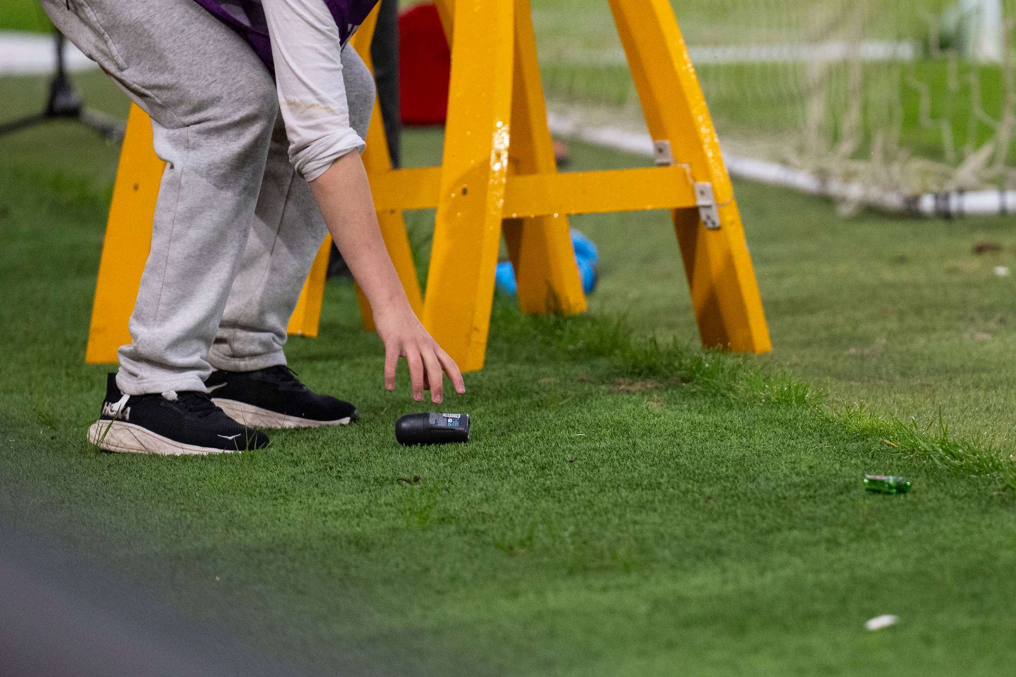 Deodorant og lita glassflaske på grasmatta på Brann stadion.