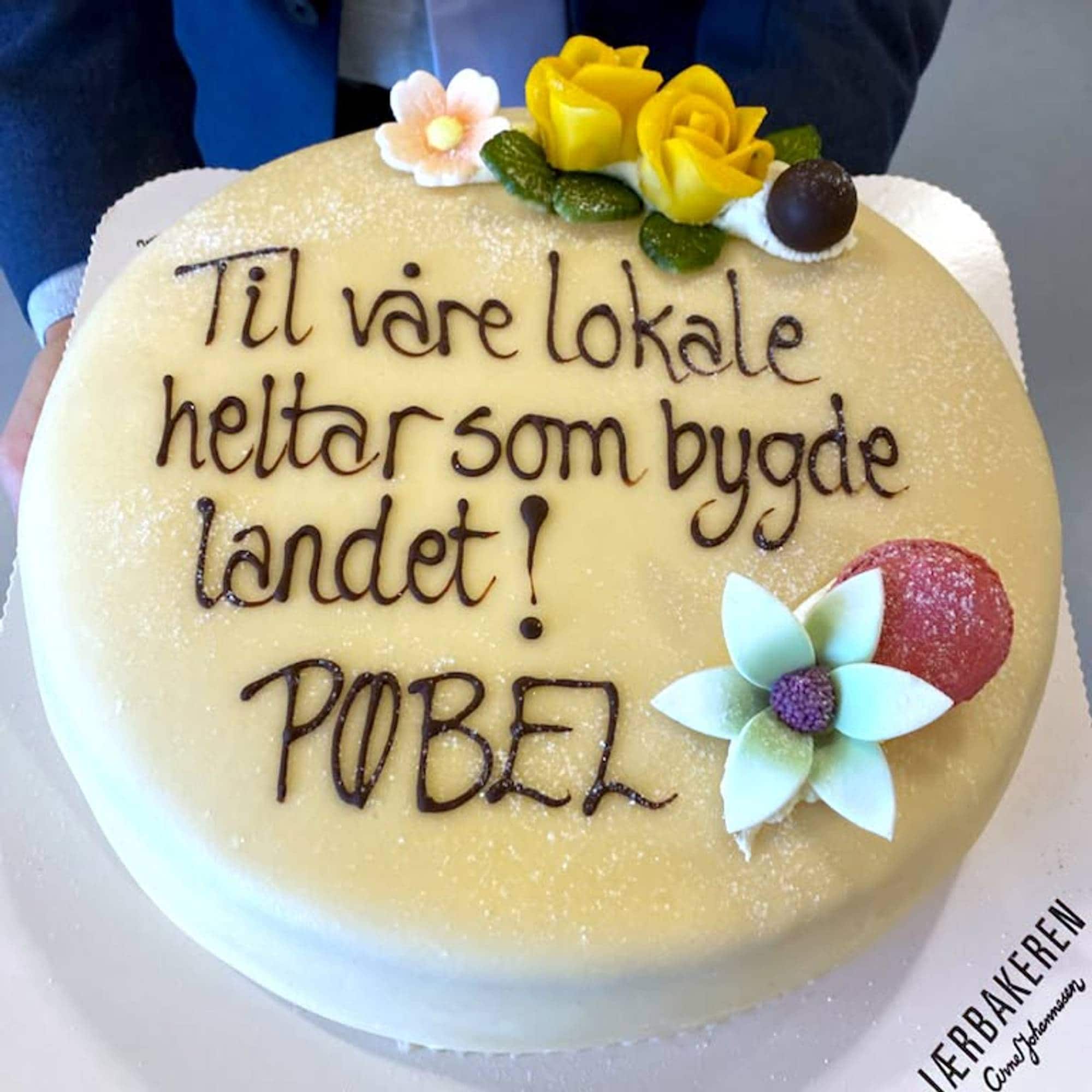 En bløtkake der det står "til vårelokale helter som bygde landet"