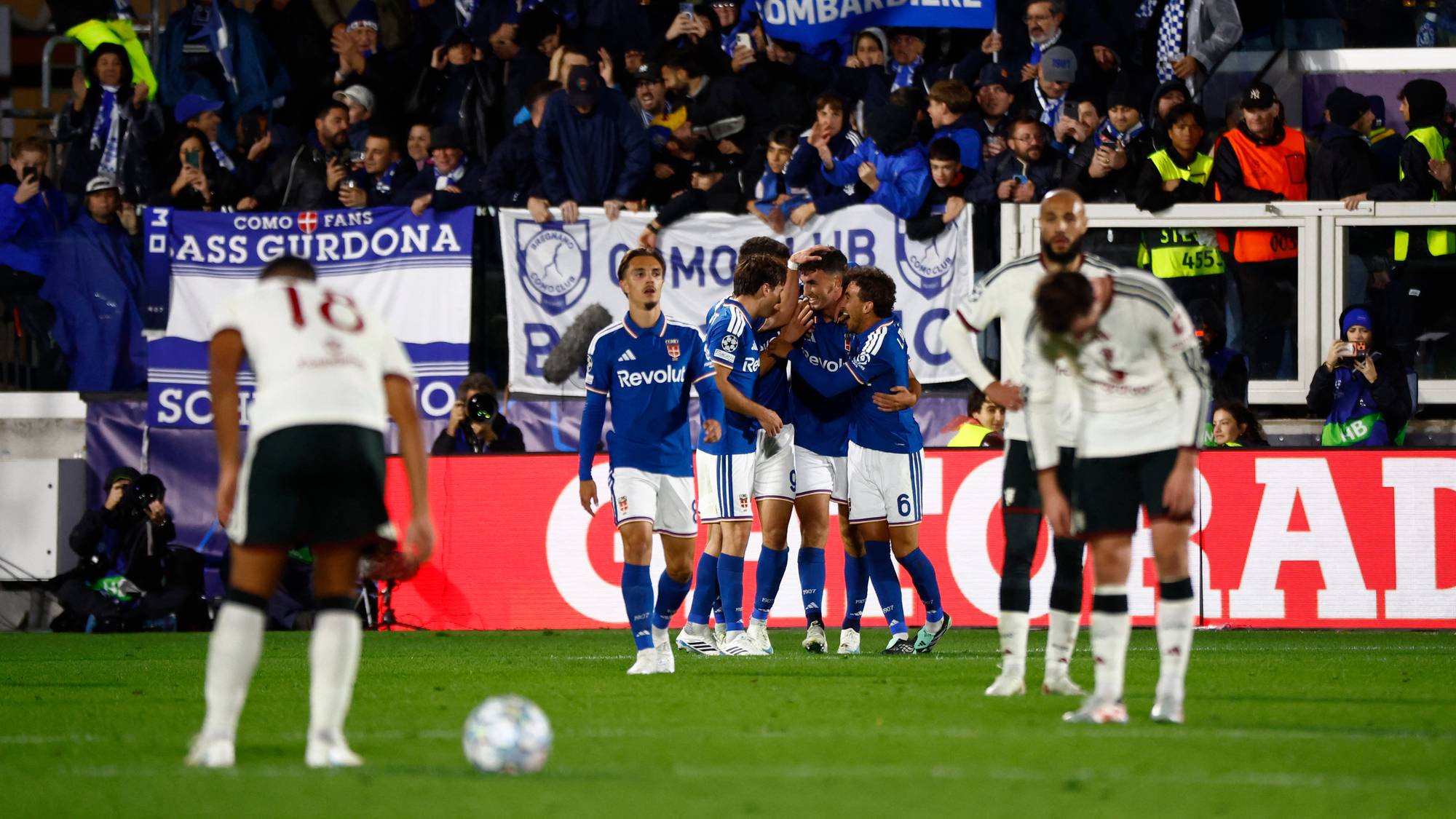 Fotballspillere i blå drakter jubler foran supportere, mens motspillere i hvitt ser skuffede ut. (Bildebeskrivelsen er laget av en KI-tjeneste)