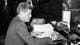 AP,NTB President John F. Kennedy skriver på et dokument ved et skrivebord.