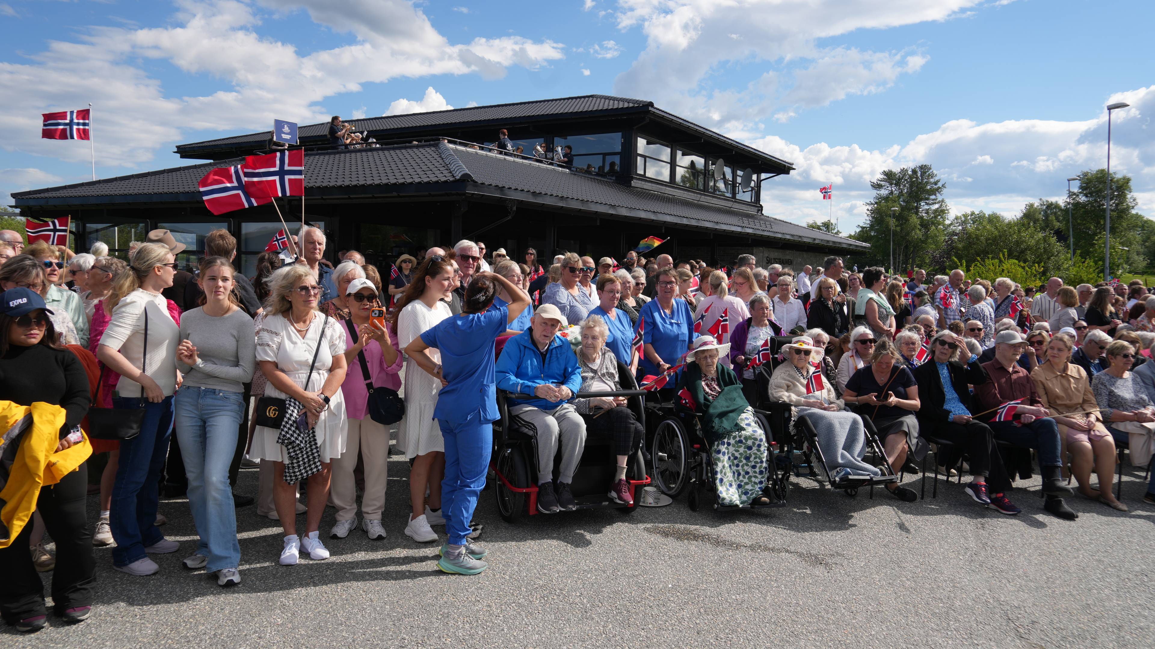 Mange mennesker som alle retter blikket mot Kong Harald og Dronning Sonja som er i Saltstraumen