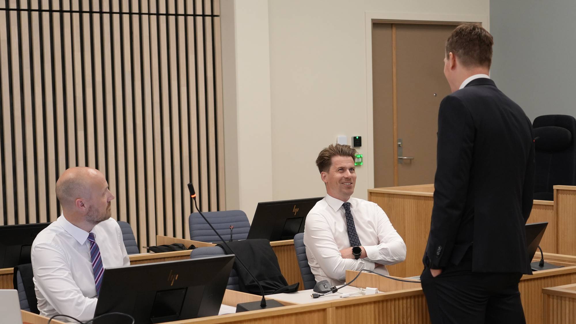 En forsvarsadvokat prater med to politiadvokater