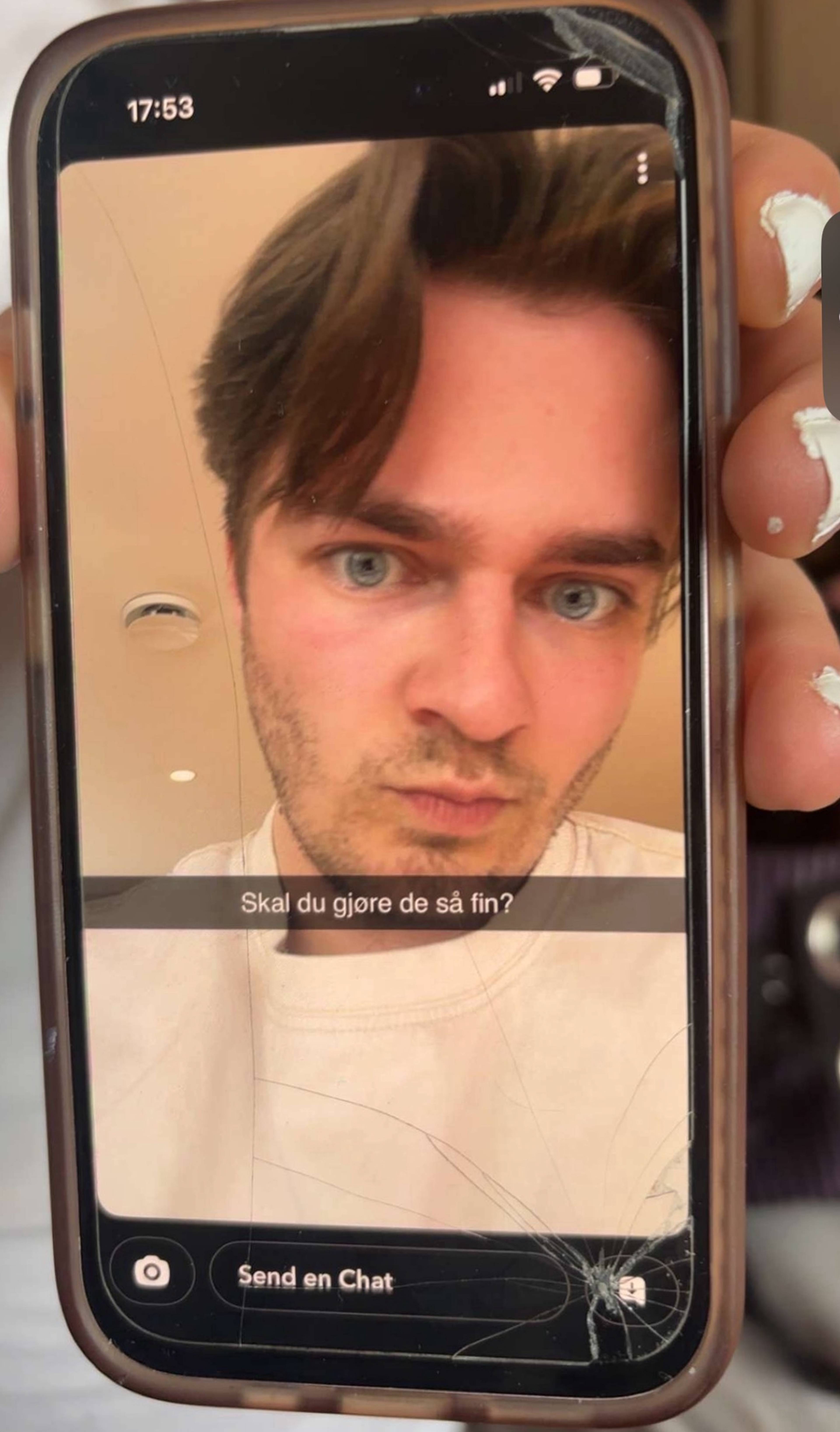 Nærbilde av en smarttelefon som viser en selfie av en ung mann med teksten Skal du gjøre de så fin? (Bildebeskrivelsen er laget av en KI-tjeneste)