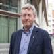 Norges Bondelag Bjørn Gimming, leder Norsk Bondelag, halvportrett foran bygg med store vinduer.