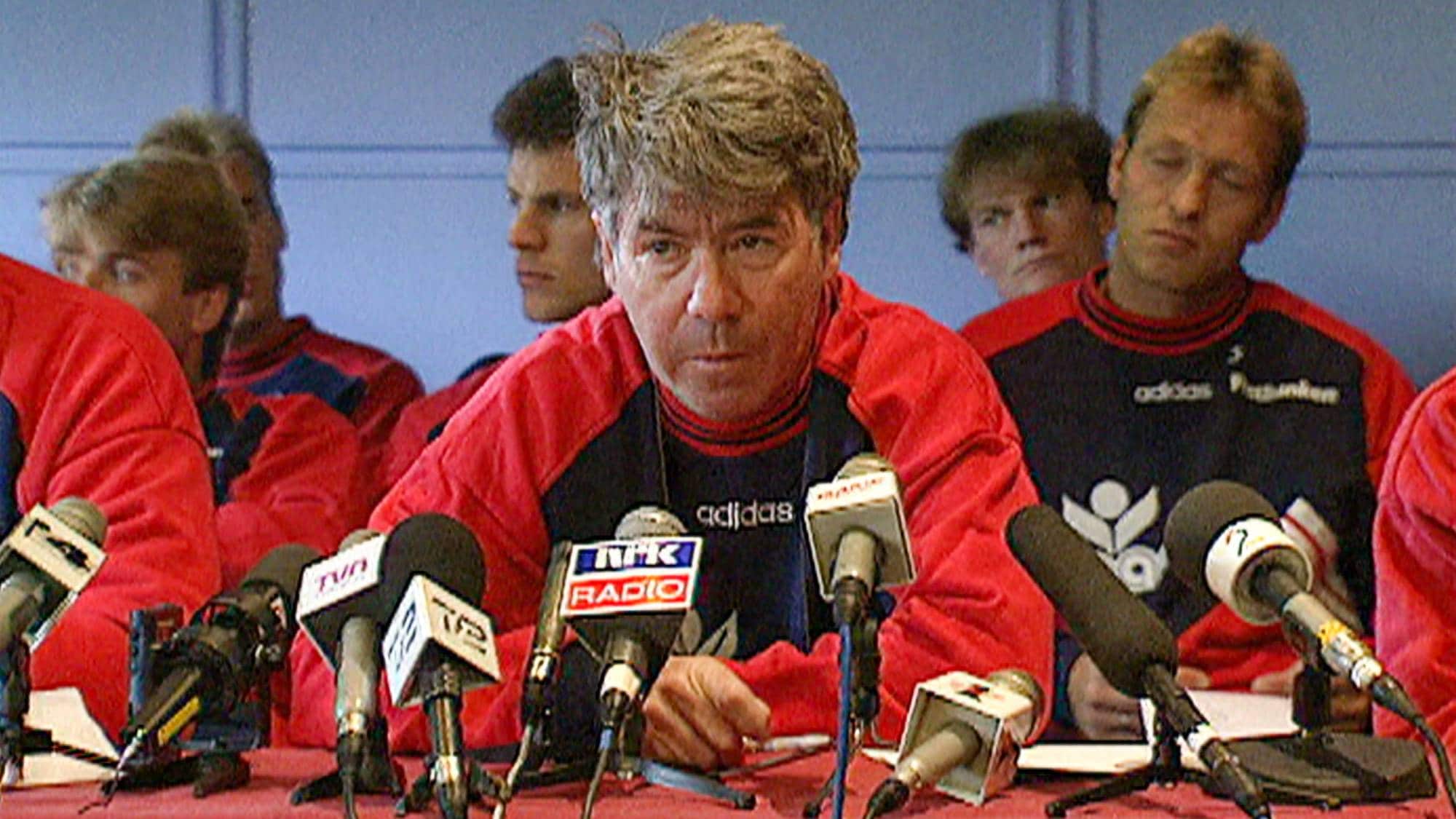 Pressekonferanse Egil Drillo Olsen, spillere i bakgrunnen.