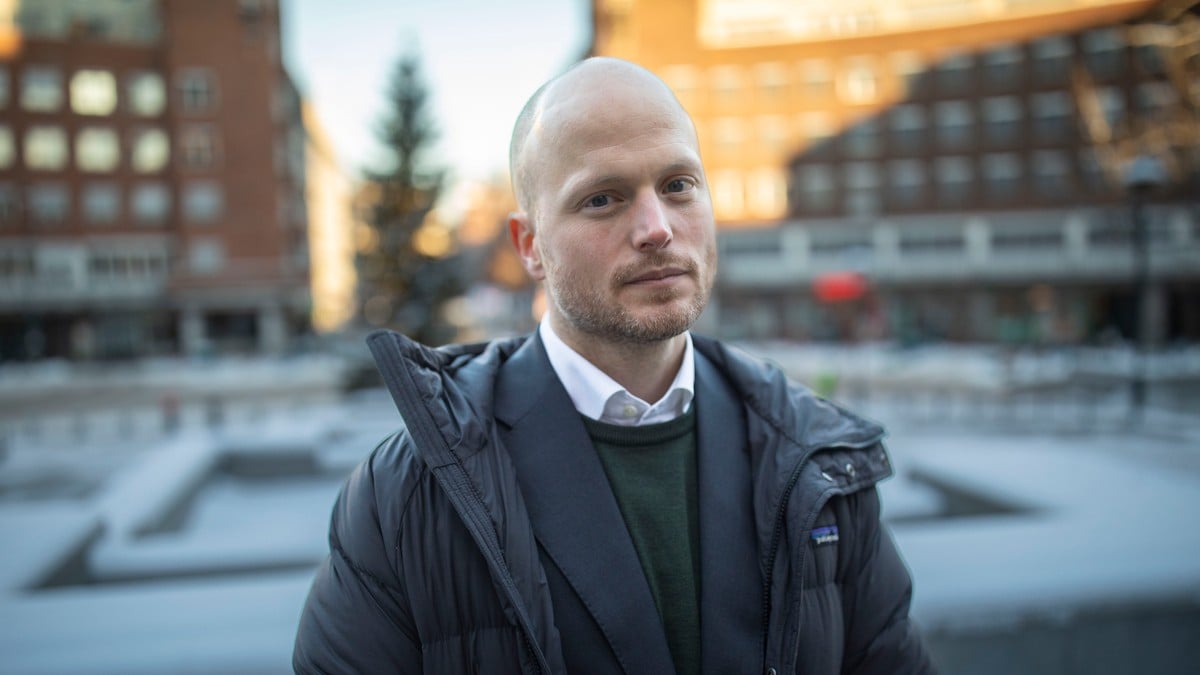 En person står i en offentlig park med snødekte områder, iført en tykk jakke over en dress. Bakgrunnen inkluderer bygninger og trær. Lyset er klart og gir en vinterlig atmosfære. Bildet fanger en rolig stund i et urbant miljø. (Bildebeskrivelsen er laget av en KI-tjeneste) FOTO: Hallgeir Braastad/NRK En person står i en offentlig park med snødekte områder, iført en tykk jakke over en dress. Bakgrunnen inkluderer bygninger og trær. Lyset er klart og gir en vinterlig atmosfære. Bildet fanger en rolig stund i et urbant miljø. (Bildebeskrivelsen er laget av en KI-tjeneste) FOTO: Hallgeir Braastad/NRK