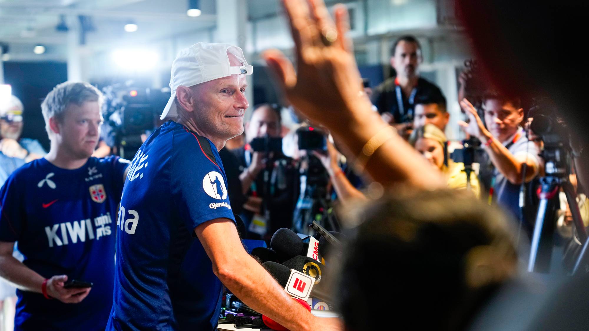 Landslagstrener Ståle Solbakken svarer på spørsmål under en pressekonferanse med mange medier. (Bildebeskrivelsen er laget av en KI-tjeneste)