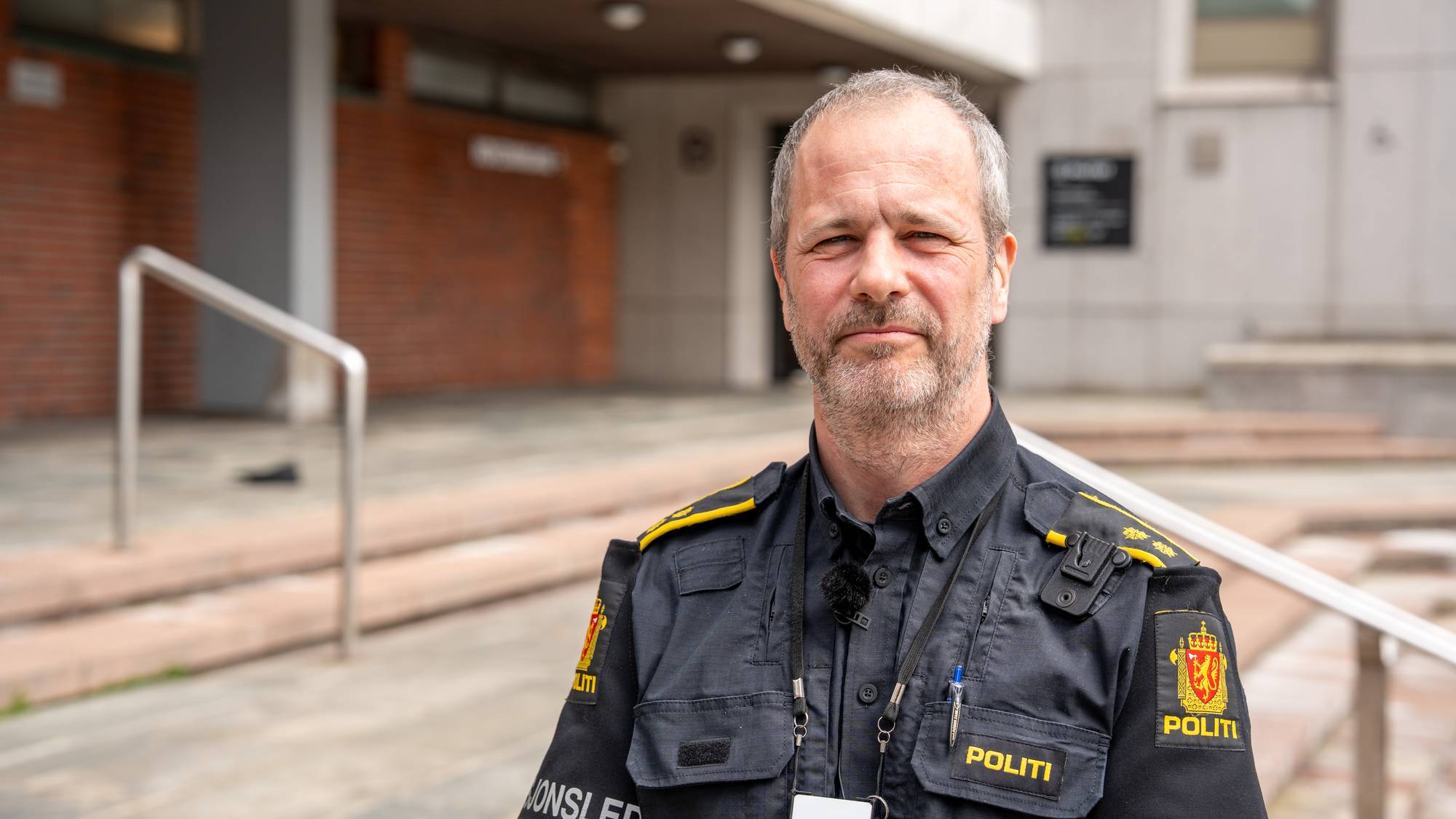 Operasjonsleder Michelsen står i uniform foran politihuset i Bergen. 