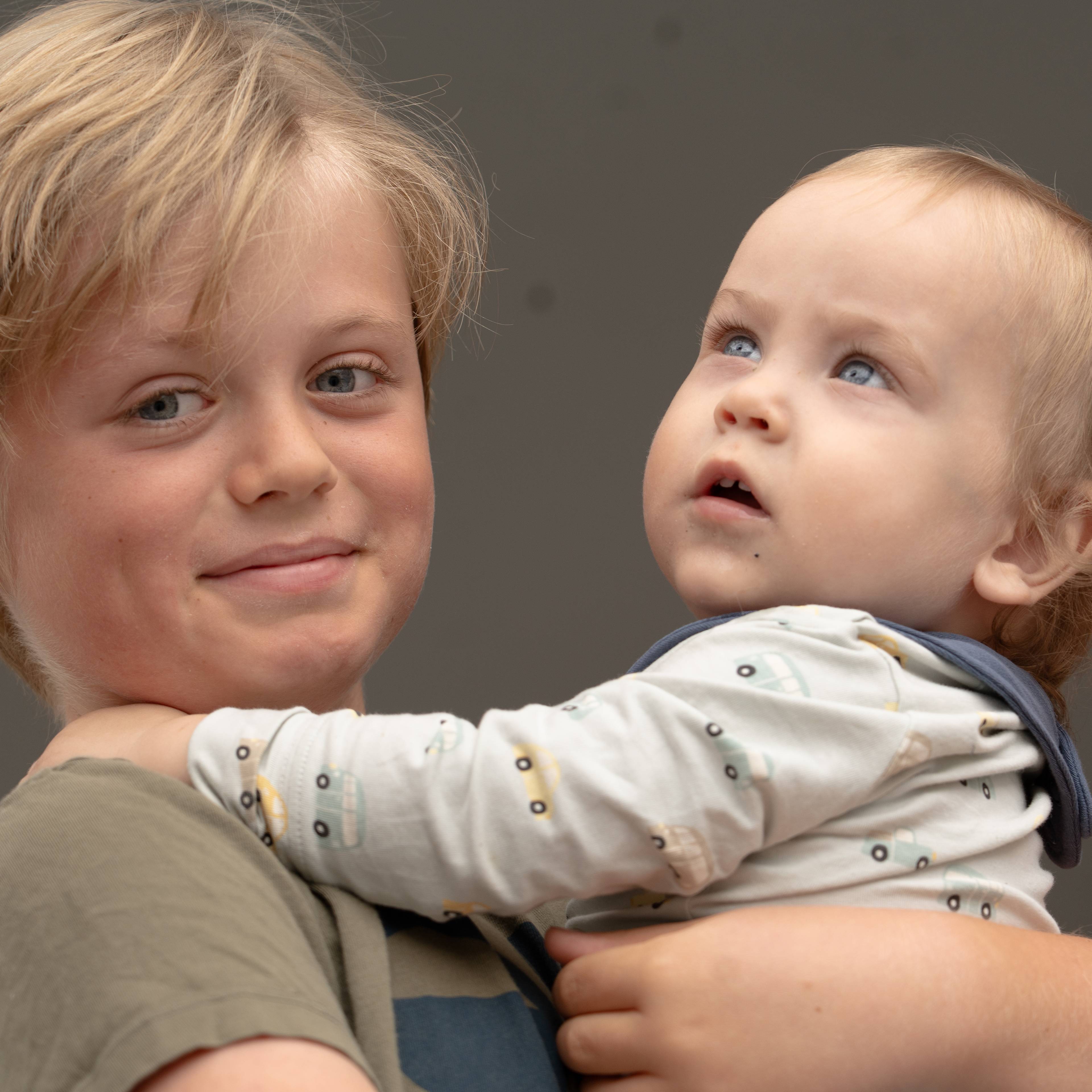 En gutt holder en baby