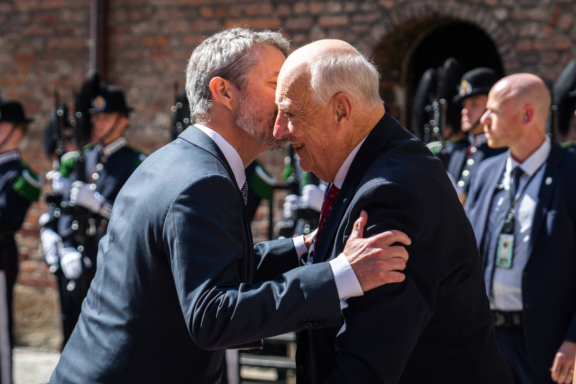 Kong Frederik gir kong Harald en klem og et kinnet når han ankommer regjeringens lunsj for det danske kongeparet