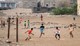 Foto: Saleh Al-obeidi / AFP Barn spiller fotball med krigsruiner i bakgrunnen