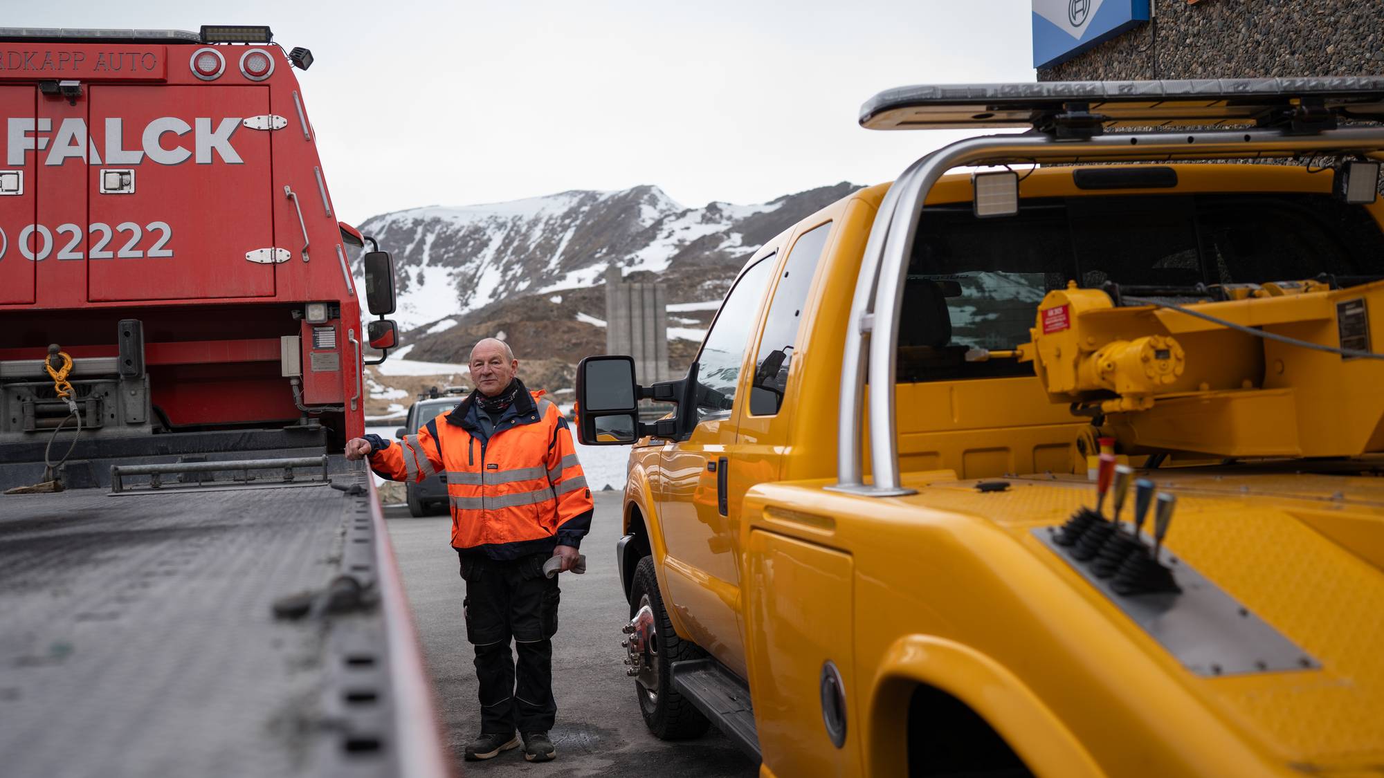 Daglig leder ved Nordkapp Auto, Arve Olsen, står mellom to bilbergingsbiler.