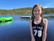 Kai Erik Bull / NRK Ebba Strøm Mathisen står på bryggekanten ved en innsjø i en dryppende våt, sort badedrakt der det står New York og tallet 78. Bak henne flyter en vanntrampoline og en flytebrygge.