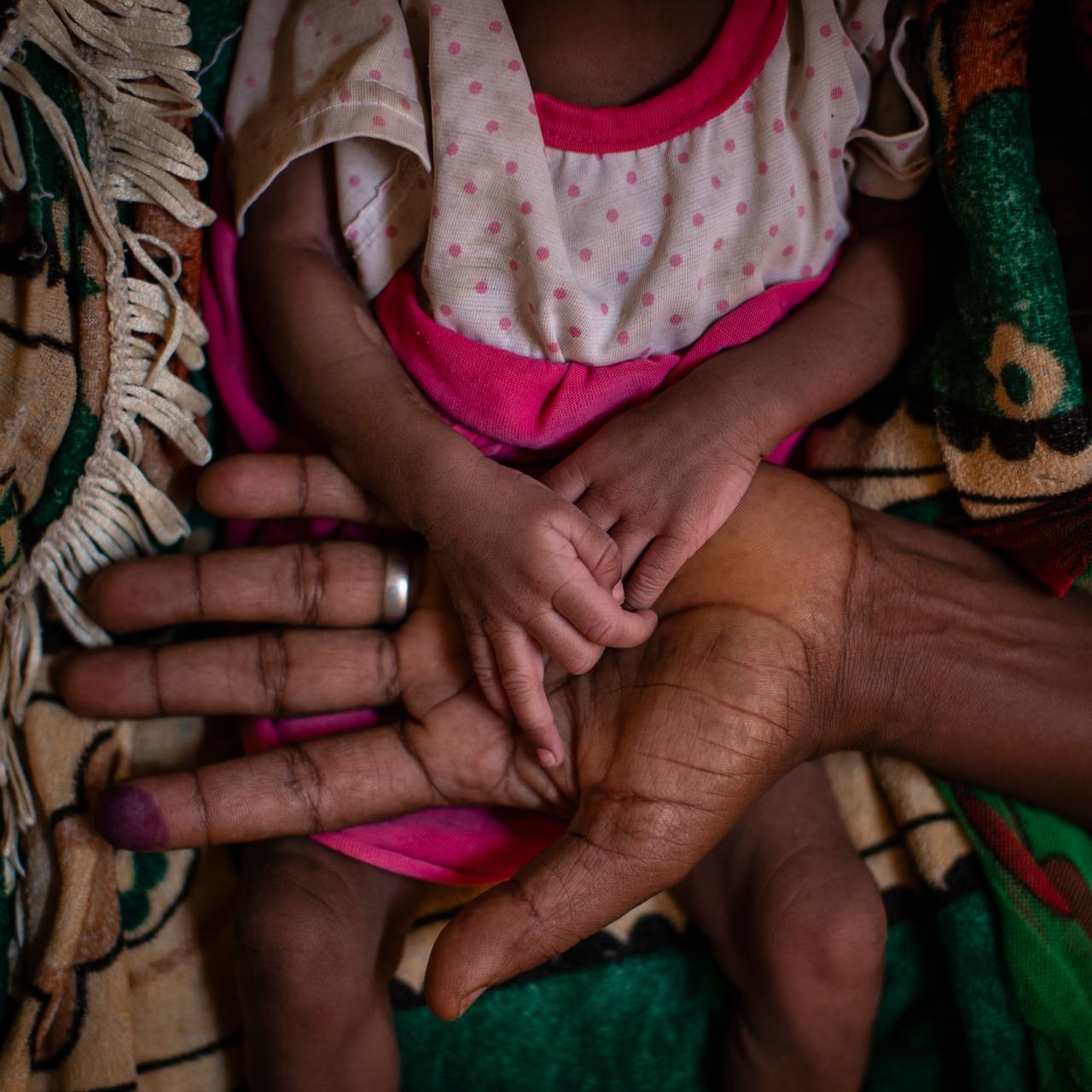 Abeba Gebru (37) fra landsbyen Getskimilesley holder hendene til sin underernærte datter Tigsti Mahderekal (20 dager gammel). Hun gikk 12 dager for å få det sultne barnet sitt til en medisinsk klinikk. - Hun overlevde fordi jeg holdt henne nær magen og fortsatte å gjemme meg under den utmattende reisen, sier hun.