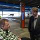 Vidar Eidhammer / NRK En mann i rullestol snakker med en stående mann på en bussterminal.