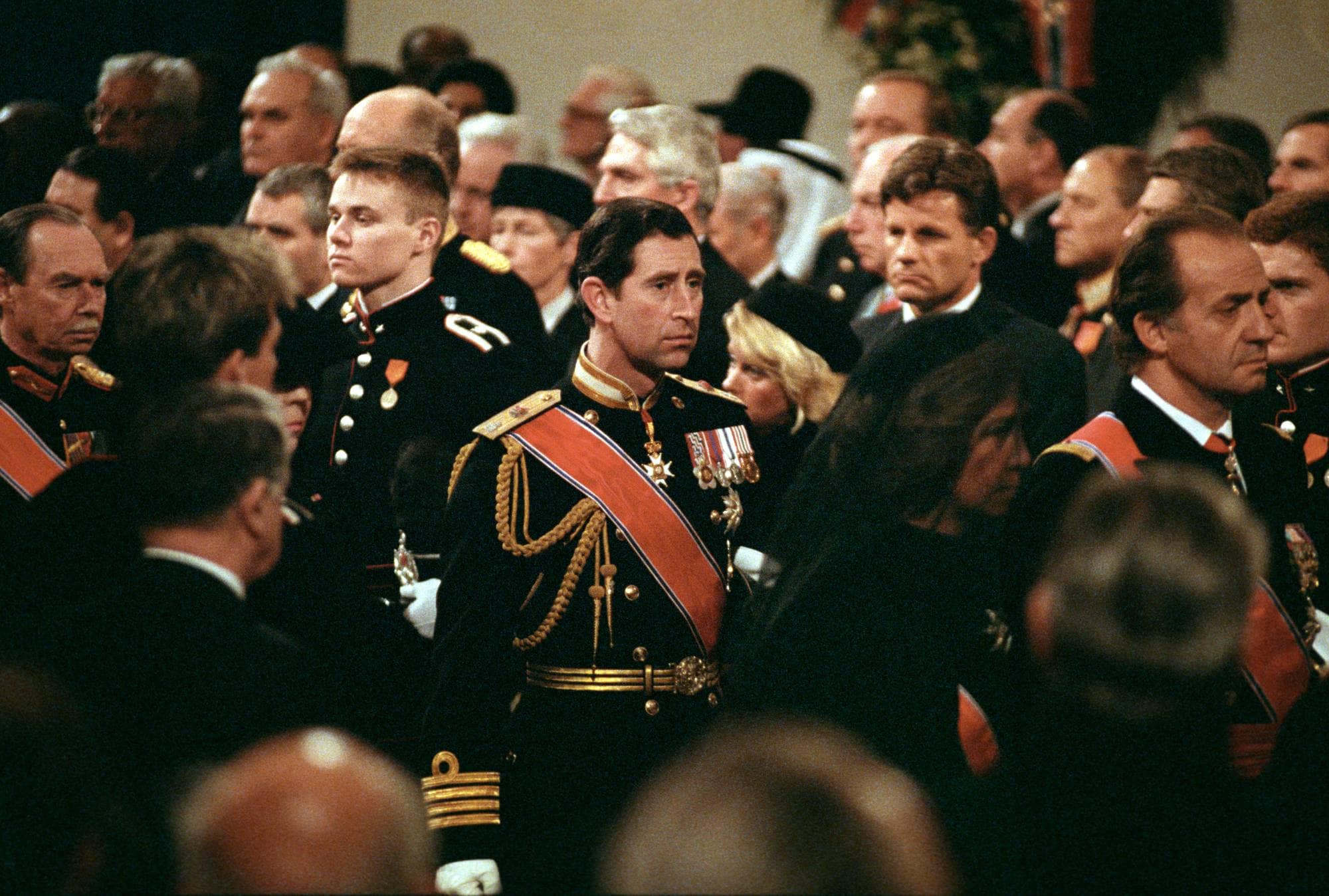 Kong Olav 5 sin begravelse, der flere mennesker står oppreist, i midten den britiske prince charles. 