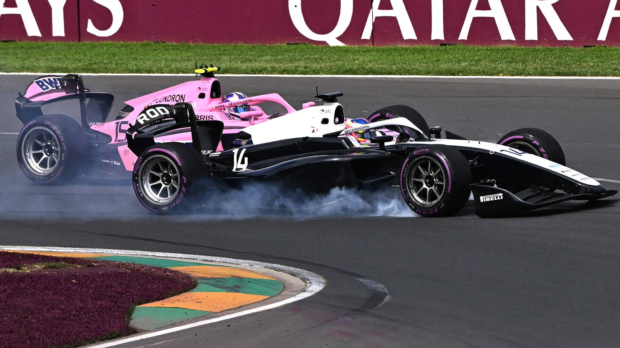 To Formel 1-biler krasjer i svingen under et løp. Røyk stiger fra dekkene. Bakgrunnen viser et gjerde med sponsorreklame. (Bildebeskrivelsen er laget av en KI-tjeneste)