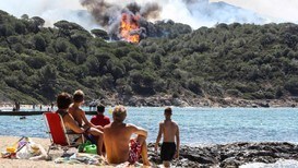 Turister ser på skogbrann i La Croix-Valmer - Foto: VALERY HACHE/AFP