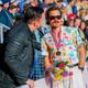 Foto: Heiko Junge / NTB Mann med solbriller og medalje samt blomsterbukett står i samtale med en mann i skinnjakke. (Bildebeskrivelsen er laget av en KI-tjeneste)