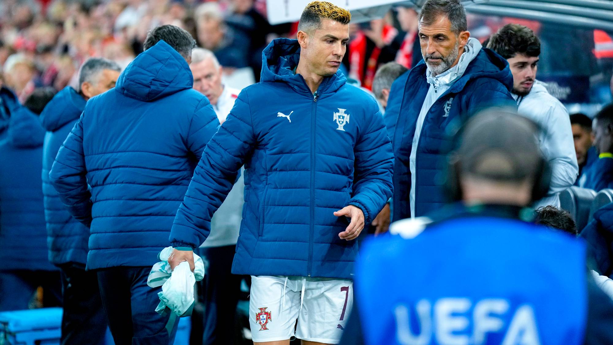 Cristiano Ronaldo og støtteapparat i Portugal-jakker på sidelinjen under en fotballkamp. (Bildebeskrivelsen er laget av en KI-tjeneste)