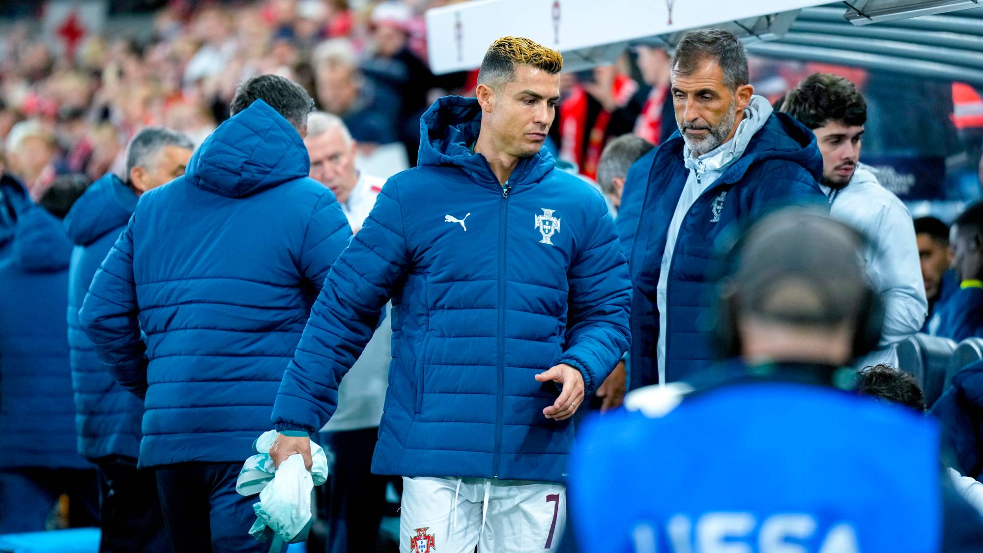 Cristiano Ronaldo og støtteapparat i Portugal-jakker på sidelinjen under en fotballkamp. (Bildebeskrivelsen er laget av en KI-tjeneste)