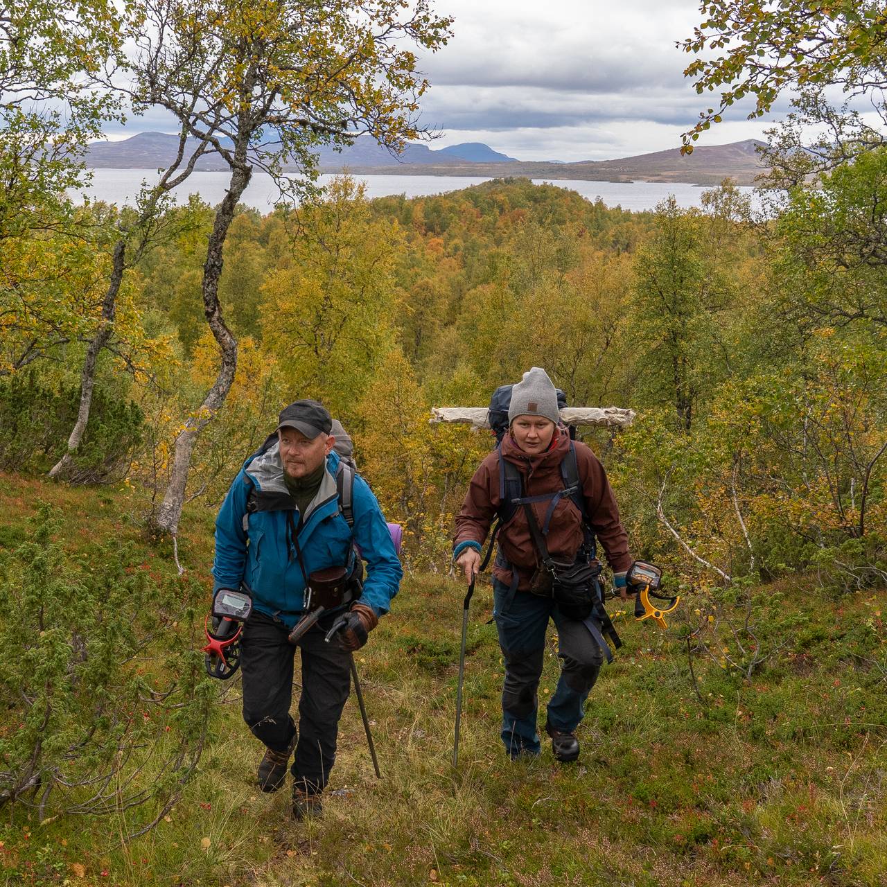 to personer går i skogsterreng