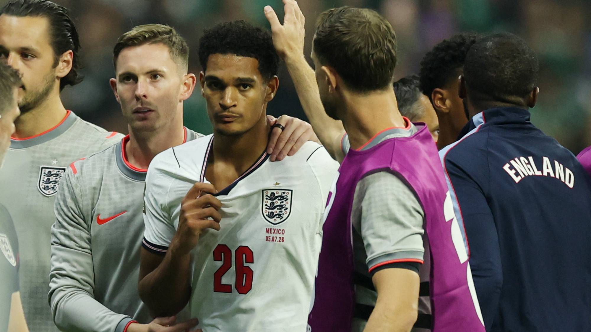 Fotballspiller fra England med nummer 26 på drakten får støtte fra lagkamerater på banen. (Bildebeskrivelsen er laget av en KI-tjeneste)