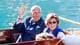 Foto: Lise Aaserud / NTB Kong Harald vinker fra en båt sammen med dronning Sonja. (Bildebeskrivelsen er laget av en KI-tjeneste)
