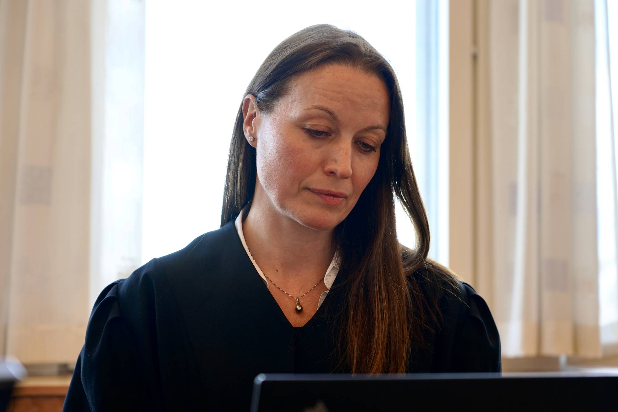 Kvinne iført advokatkappe i retten.