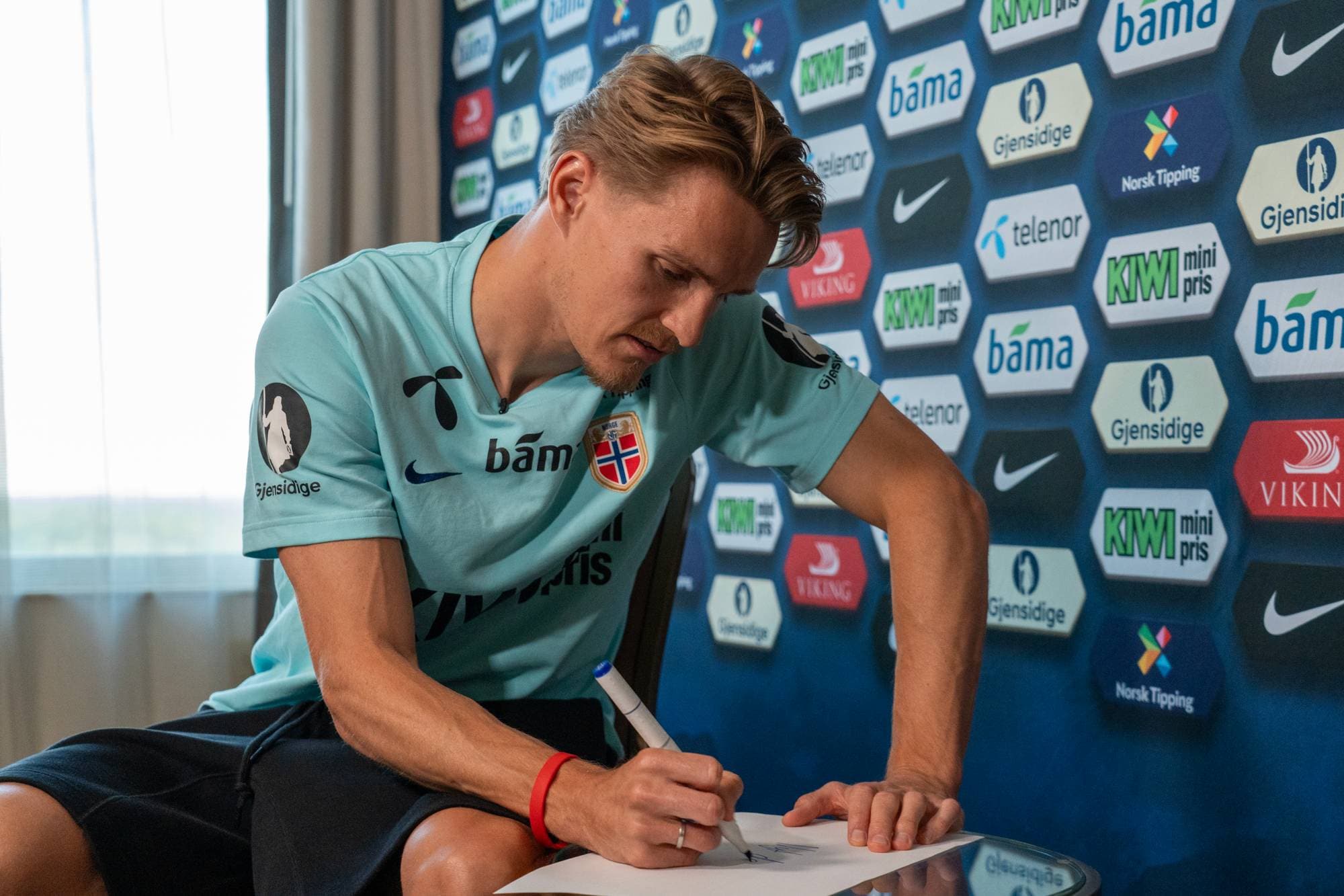 Norsk fotballspiller på et hotellrom blir intervjuet
