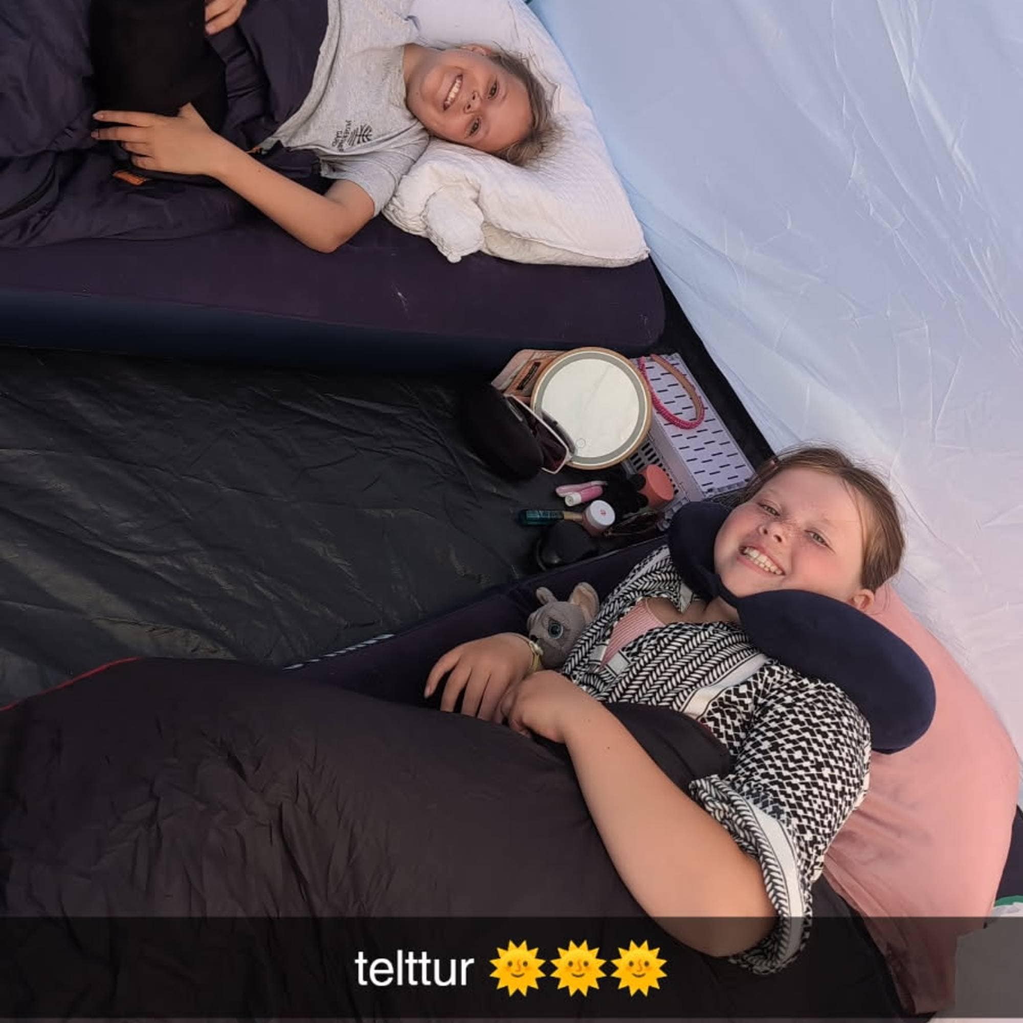 To jenter inne i et telt. 