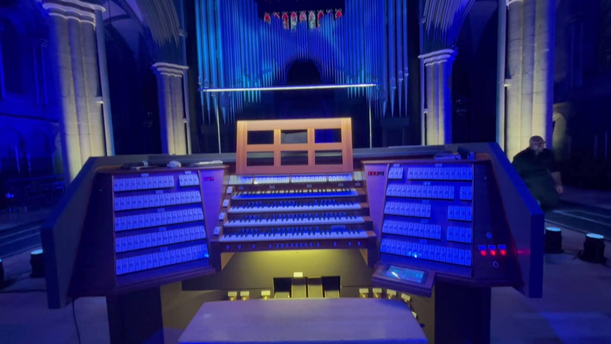 Orgel i en kirke opplyst av blått lys. 