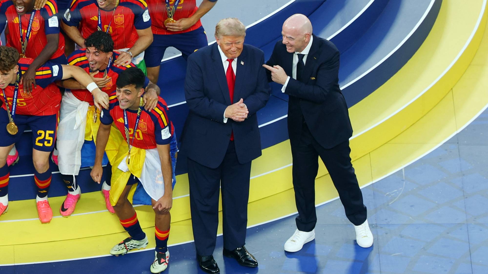 Donald Trump og Gianni Infantino sammen med spanske fotballspillere på en seierspall. Illustrasjon. (Bildebeskrivelsen er laget av en KI-tjeneste)