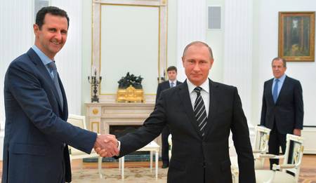 Russian President Vladimir Putin shakes hands with Syrian President Bashar Assad as Russian Foreign Minister Sergei‌ Lavrov‌ looks on, in Moscow, October 20, ‍2015