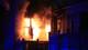 Peder Gjersøe / NTB En bygning brenner kraftig, med flammer som slår ut fra vinduer. Røyk fyller luften, og omgivelsene er svakt opplyst av blå lys. Den brennende konstruksjonen har en balkong, og vinduene er ødelagt av varmen. Ingen personer er synlige i bildet.